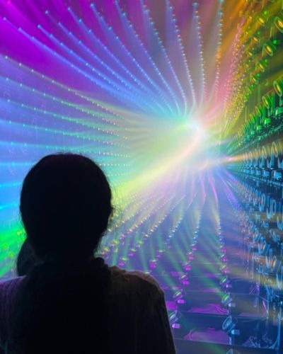 Person silhouetted in a colorful light installation