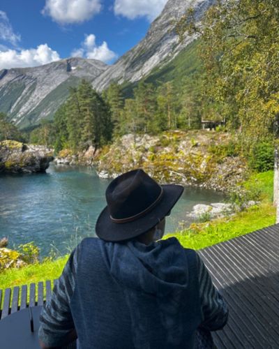 Traveler overlooking a turquoise river and mountain valley